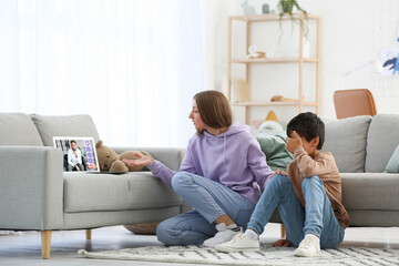 Mother and her little son video chatting with psychologist at home