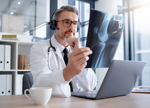 Doctor, x ray and man with headset and laptop in hospital for healthcare or online consultation. Thinking, radiology telehealth and mature medical physician looking at mammogram picture or bone xray.
