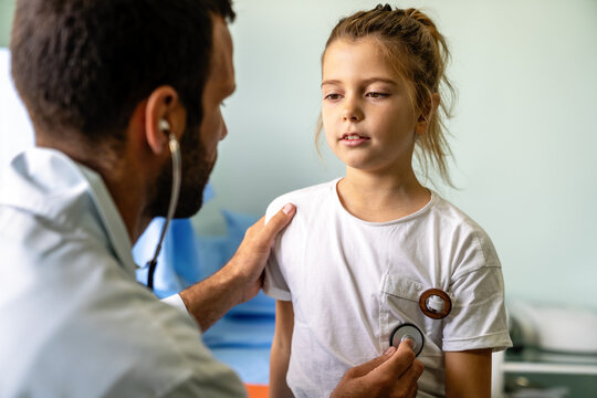 Pediatrician doctor examining little girl in a clinic