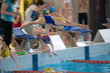Swimmer girl start from the starting table in the pool