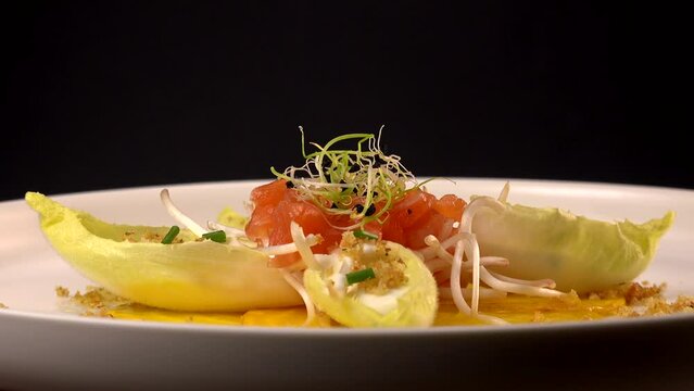 Recipe for salmon gravlax salad, endives filled with creame fresh, chives, yellow chioggia beetroot and leek shoots, white balsamic vinegar sauce. High quality video