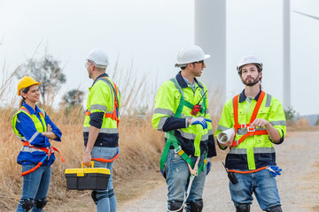 Teamwork engineer worker wearing safety uniform discuss operational planning at wind turbine field renewable energy. technology protect environment reduce global warming problems.