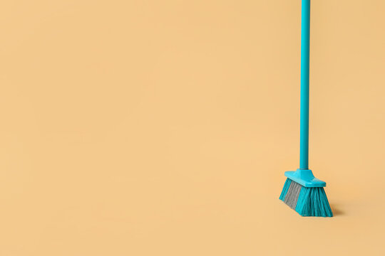 Blue cleaning broom on orange background