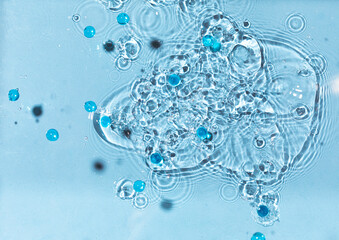 Abstract water, cosmetic background with waves and ripples and spherical granules. Concept of therapeutic moisturizing cosmetics