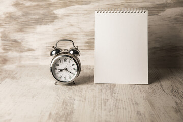 Alarm clock and notebook on the table