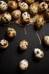Obraz premium Quail eggs on a black table.