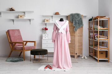 Interior of fashion designer's studio with mannequin, clothes and armchair