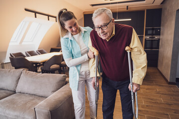 Nurse home caregiver is assisting old man at his home. Professional health support for elderly...