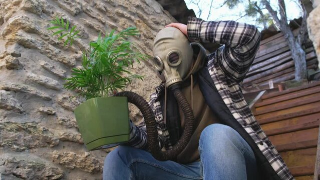 a man in a gas mask protects the plant after an environmental disaster