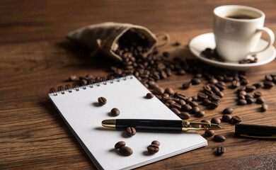 Cup of coffee, notebook and coffee beans