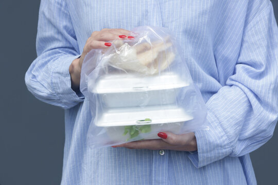 Woman's Hands Holding PVC Plastic Bag With Takeaway Foam Lunch Boxes. Single Use Food Containers, Donation Concept.