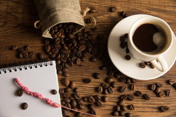 Cup of coffee, notebook and coffee beans