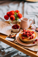 Breakfast in bed: pancakes, flowers and photos of couple