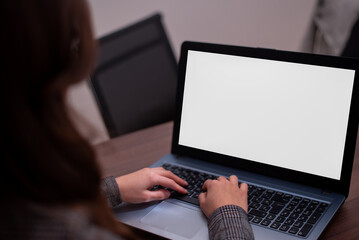 Girl typing on her laptop with white screen