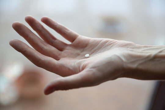 Image of woman with pills in hand