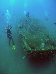 some divers in a small sunken ship in the crystal clear waters of the caribbean sea