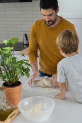 young man making homemade bread with his son in his home kitchen