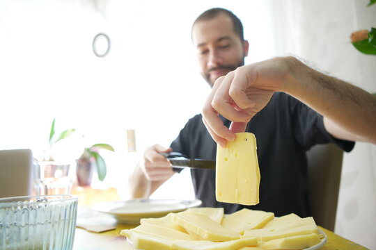 Young Man Preparing Raclette Cheese 