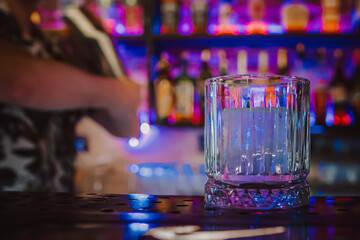 empty glass with ice on a bar counter in bar or pub