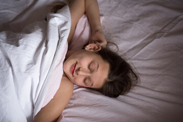 Obraz na płótnie Canvas young girl sleeps in bed. girl wakes up