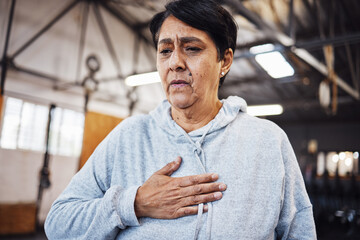 Senior woman with chest pain or injury in the gym after a intense workout or training. Healthcare, sick and elderly lady in retirement with asthma or breathing problem during exercise in sport center - obrazy, fototapety, plakaty