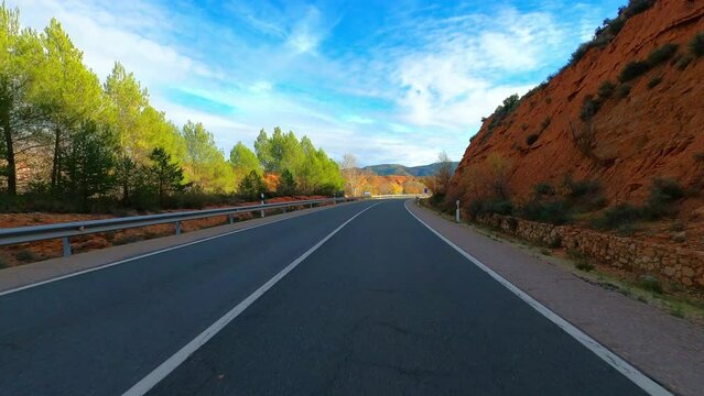 Driving vehicle on a long asphalt straight road in the nature with blue sky and horizon in background. Concept of travel and transport. Mountains national park. Drive to destination. Holiday vacation.