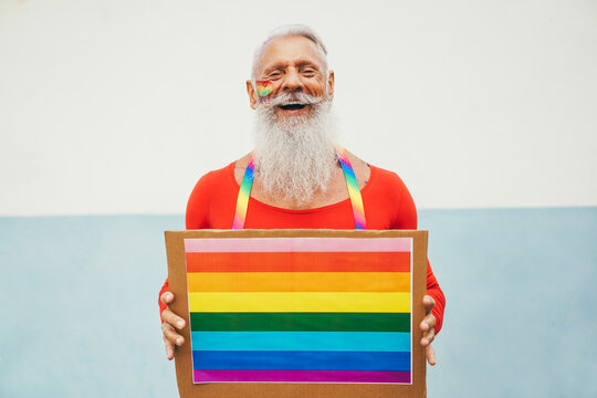 Hipster senior man at gay pride holding rainbow lgbt banner - Focus on face