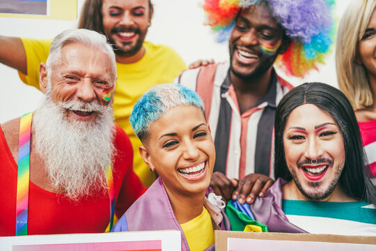 Gay people having fun at pride parade with LGBT flags outdoors - Focus on lesbian face