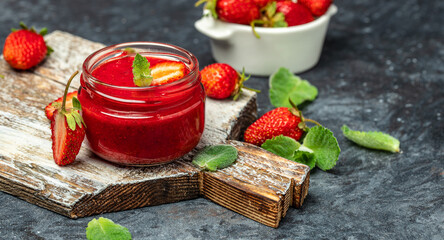 Jar of strawberry jam . Homemade strawberry marmelade and fruits on wooden board. Long banner format