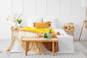 Interior of bedroom with tree branches, Easter eggs and rabbits