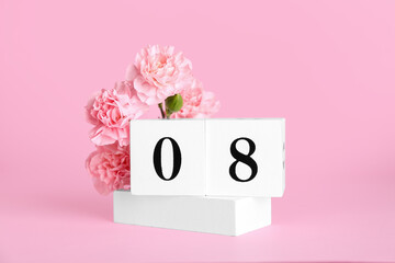 Cube calendar with date MARCH 8 and beautiful carnation flowers on pink background. Women's Day celebration