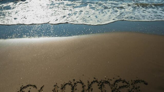Word Summer drawn on the sandy sea beach.