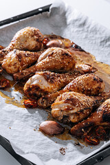 baked chicken drumsticks with sesame, honey and soy sauce, onion and spices