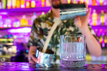 empty glass with ice on a bar counter in bar or pub