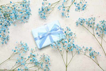 Beautiful gypsophila flowers and gift for Women's Day celebration on white background