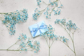 Beautiful gypsophila flowers and gift for Women's Day celebration on grey background