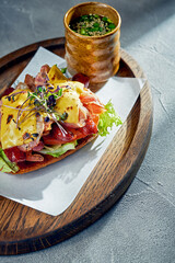 Toast with bacon, sausages and melted cheddar cheese. Concrete background, morning light. Close up, selective focus