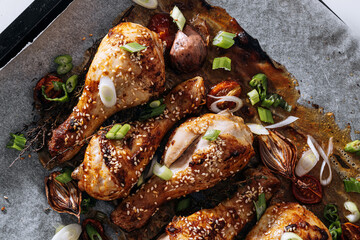baked chicken drumsticks with sesame, honey and soy sauce, onion and spices