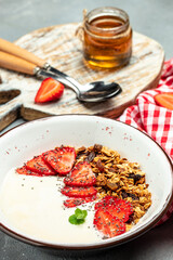 Bowl of homemade granola with fresh strawberry, chia seeds and honey on a light background. Delicious breakfast or snack. banner, menu, recipe place for text, top view
