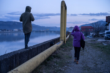 People walking in the evening on the quay of Olt river in a medical recovery resort in Romania. - 569127795