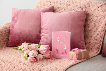 Pink tulips, gift and greeting card for Women's Day on sofa in living room, closeup