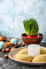 Plate with burning candle and shekarbura on table, closeup. Novruz Bayram celebration