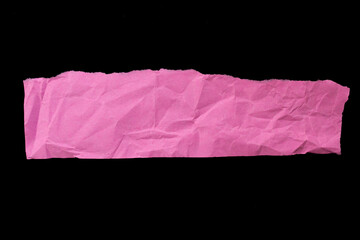 Crumpled pink paper piece isolated on black background