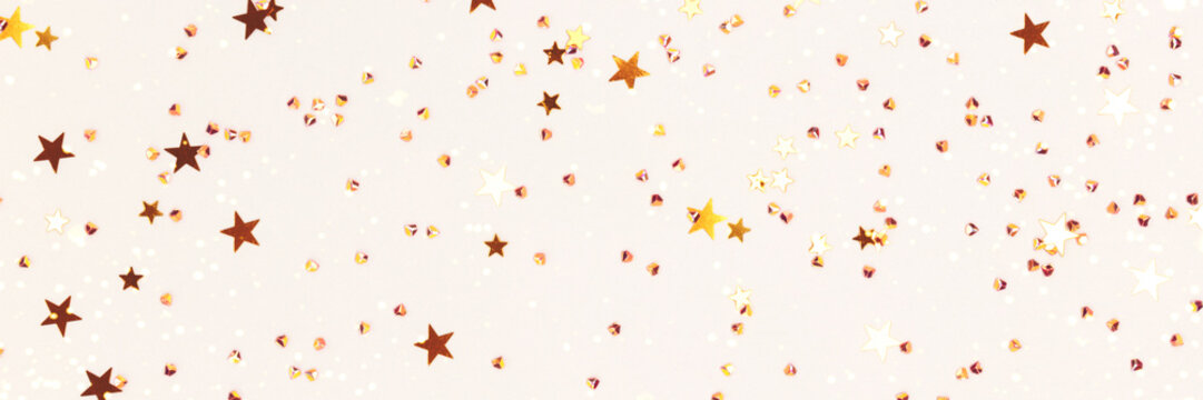 Banner with golden stars and crystals confetti on a gray background. Festive concept. Selective focus.