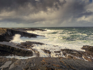 Stunning rough coast line of Ireland near Bridges of Ross, county Clare. Irish seascape. Beautiful nature scenery with cliffs and ocean and dramatic sky. Travel landmark.