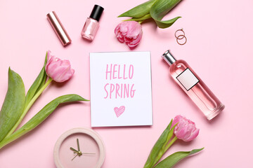 Composition with card, bottle of perfume, tulip flowers and cosmetics on pink background. Hello...