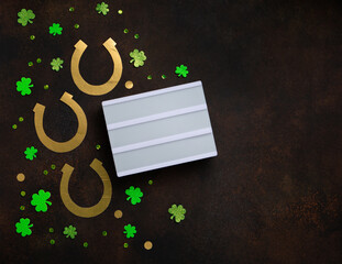 Golden Horseshoe, Gold Coins and Clover Leaves Shamrocks on Brown Background.