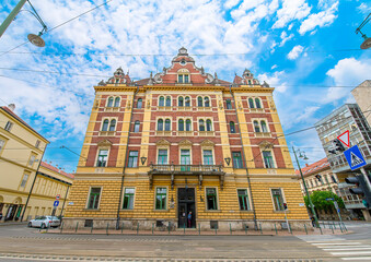Fototapeta premium Front view the facade of beautiful old building with old sculptures in the city center of Szeged, Hungary 