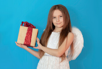 Banner for Valentine's Day. Angel girl with real gift, studio portrait. Playful angelic little...