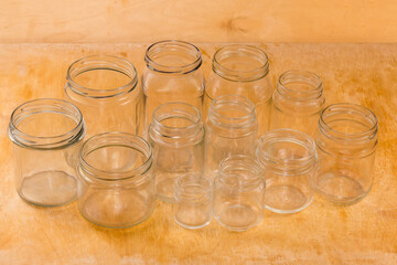 Empty glass jars different sizes on a wooden surface
